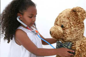 Girl listening to teddy bears heart