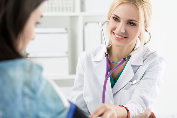 Picture of a Patient having their blood pressure checked by a Doctor